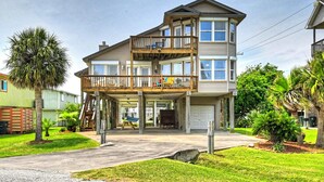 Une maison à deux étages avec un balcon, une véranda et un garage.