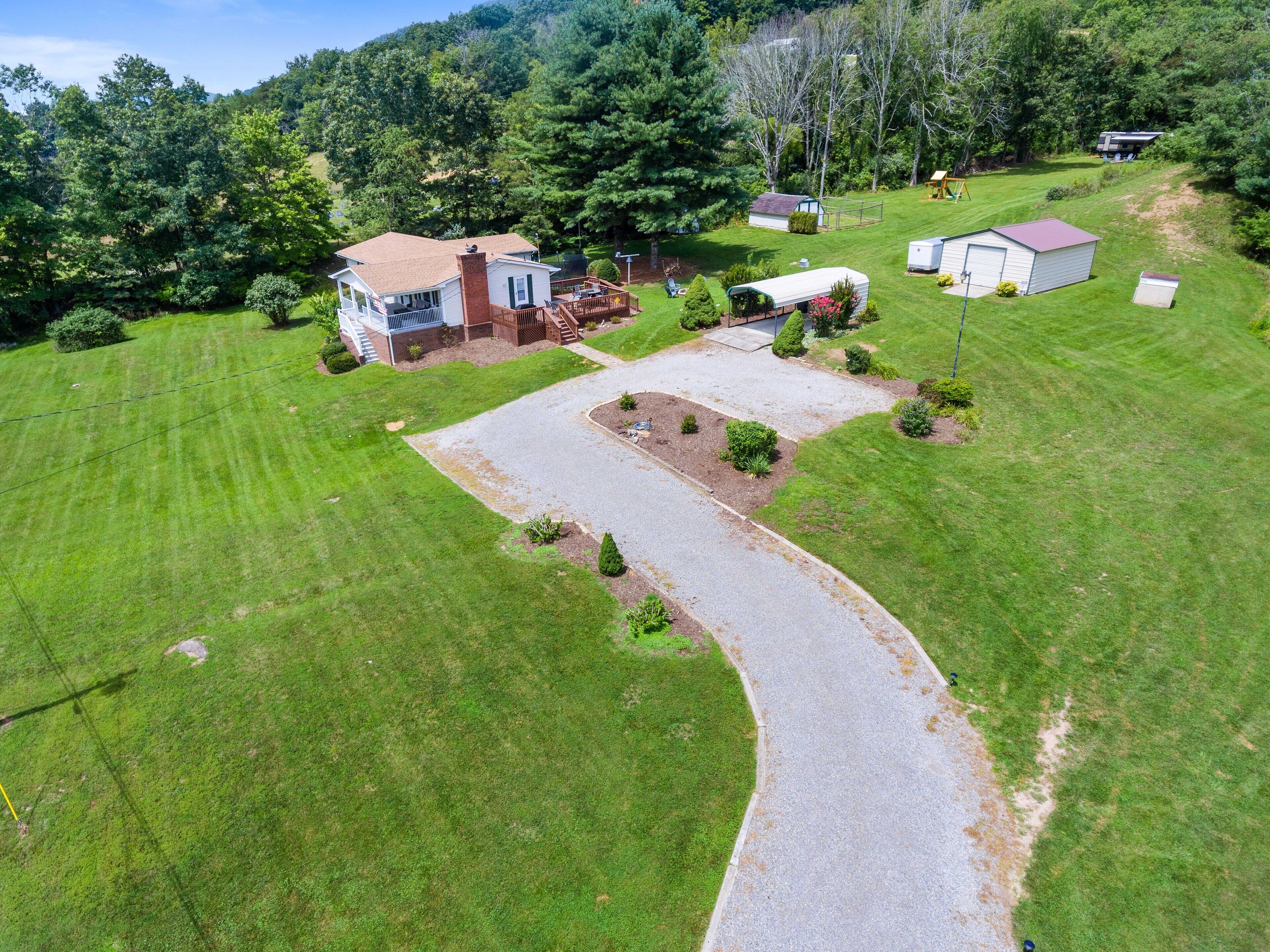 A residential property with a main house, a detached garage, and a driveway leading to a gated entrance.