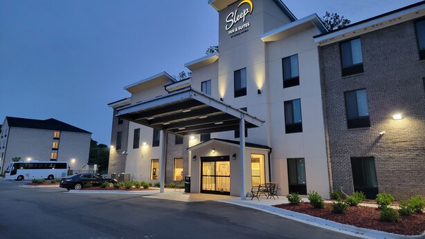 Edificio de Sleep Inn & Suites con diseño moderno, que presenta una entrada cubierta y múltiples ventanas.