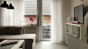 A modern living room with a wooden ceiling, a sofa, a coffee table, and a TV on a white stand. - Very nice camp, close to a large playground, swimming pool, sight-seeing dog station (Norden)