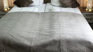 A neatly made bed with a patterned bedspread, two pillows, and two bedside lamps. - Very nice camp, close to a large playground, swimming pool, sight-seeing dog station (Norden)