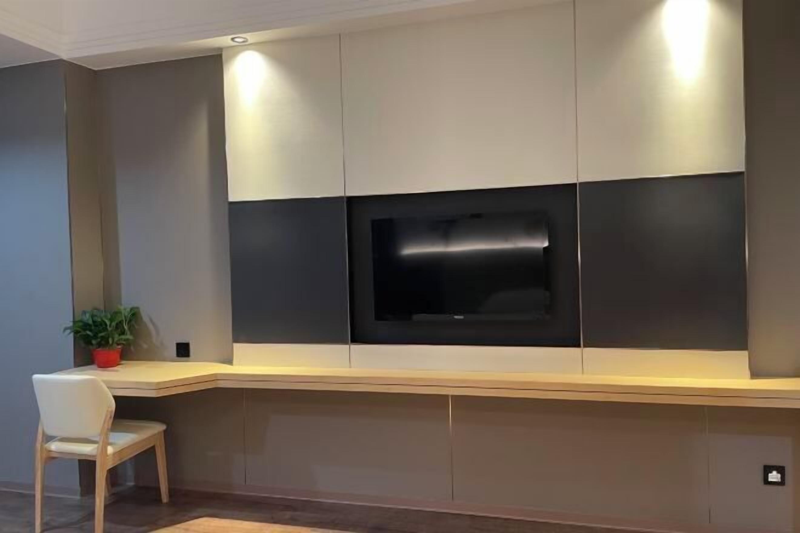 Ein modernes Wohnzimmer mit integriertem Fernseher, einem Holztisch und einem Sessel.