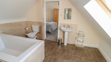 A bathroom with a bathtub, toilet, and sink.