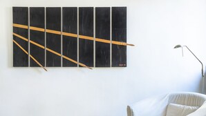 A room with a large abstract painting on the wall, a white armchair, and a floor lamp. - ACQUARELLO, SPACIOUS APARTMENT IN THE HEART OF VENICE (Venise)