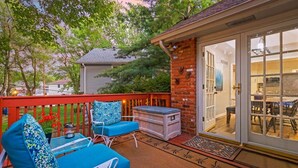 A patio with outdoor furniture, a brick wall, and a sliding glass door leading to an interior dining area. - KC Backyard Vacation (Kansas City)