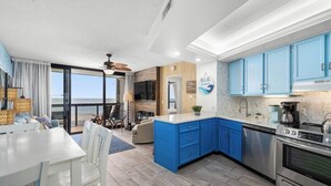 A modern kitchen with blue cabinets, a stainless steel stove, and a large island. - 2 Bdrm Oceanfront-Pool, Xbox, Pickleball, Gym, HBO (Ocean City)
