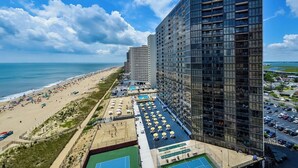 A high-rise hotel with a rooftop pool area, adjacent to a beach. - 2 Bdrm Oceanfront-Pool, Xbox, Pickleball, Gym, HBO (Ocean City)