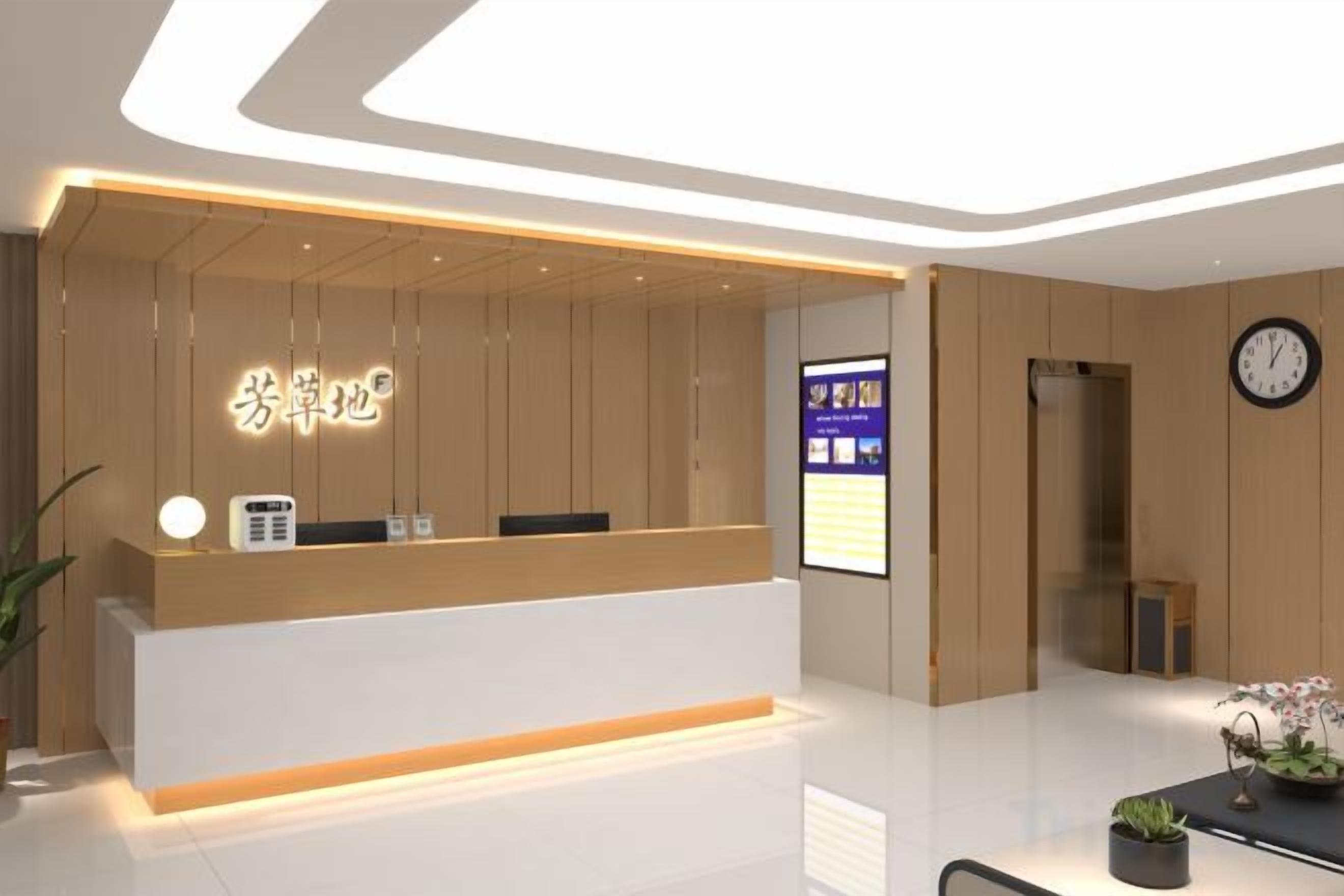A reception desk with a digital display, a clock, and a potted plant.