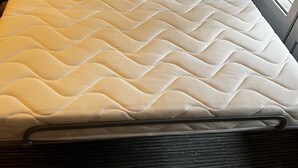 A bed with a quilted mattress, a headboard, and a framed picture above it. - Apartment near center 5 min walk and 5 min drive to beaches (La Croix-Valmer)