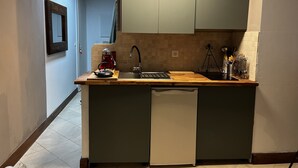 A compact kitchen with a built-in dishwasher, a coffee maker, and a sink. - Apartment near center 5 min walk and 5 min drive to beaches (La Croix-Valmer)
