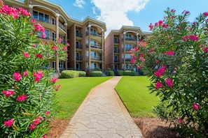 A multi-story residential building with a central pathway leading to the entrance. - BeachFront! Pool, Grill, Beach Svc! wifi, kitchen (Miramar Beach)
