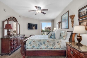 A bedroom with a bed, dresser, vanity, and a ceiling fan. - BeachFront! Pool, Grill, Beach Svc! wifi, kitchen (Miramar Beach)