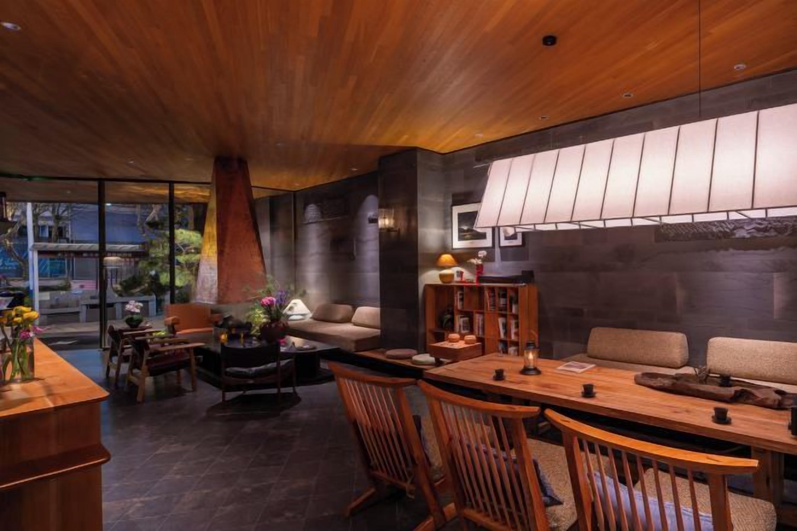 A modern interior with a wooden ceiling, a dining area, and a sofa.