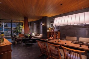 Een modern interieur met een houten plafond, een eethoek en een bank.