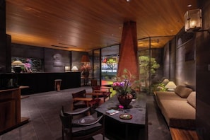 Een modern interieur met een eethoek, zitplaatsen en een uitzicht door een glazen wand.