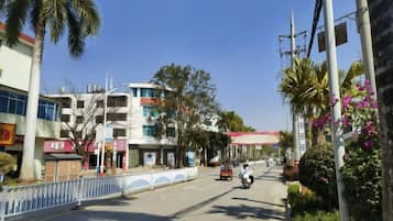 A street with buildings, a fence, and a clear sky.