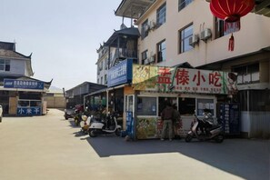 A street with shops and a food stall. - Yintai Hotel (Menglian)