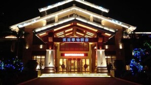 A hotel entrance with a modern design, featuring a prominent sign and illuminated entryway.