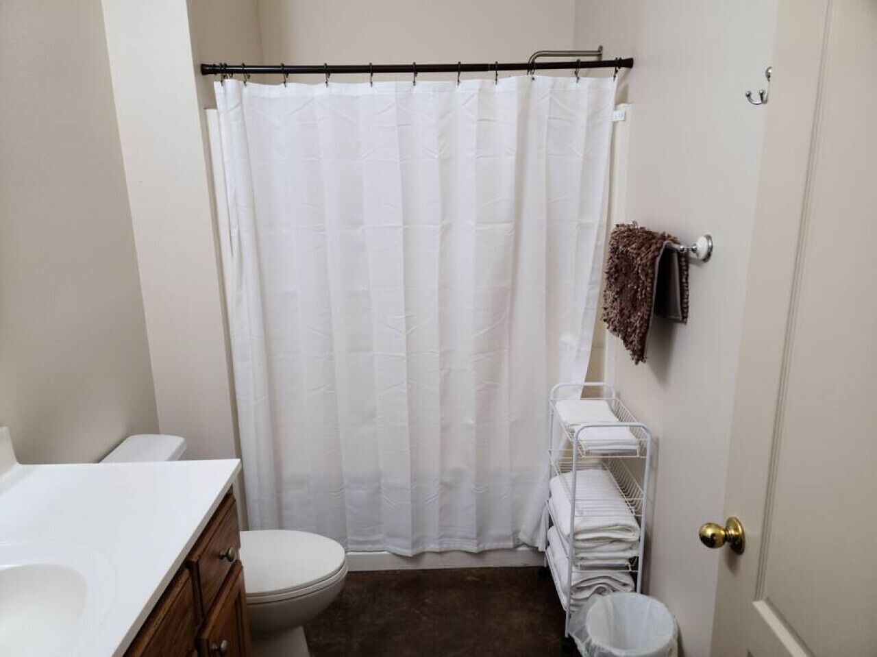 A small, clean bathroom with a white toilet, a white sink, and a shower curtain.