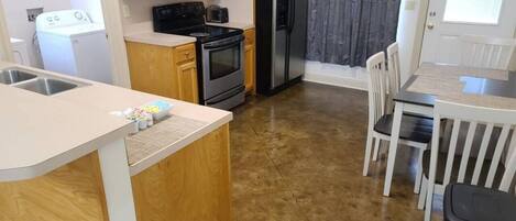 A kitchen with wooden cabinets, a microwave, a refrigerator, a stove, and a sink.