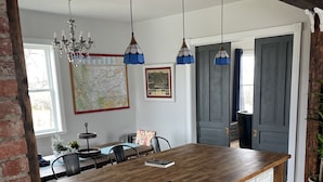 Uma cozinha com ilha de madeira, luminárias pendentes e um mapa na parede.