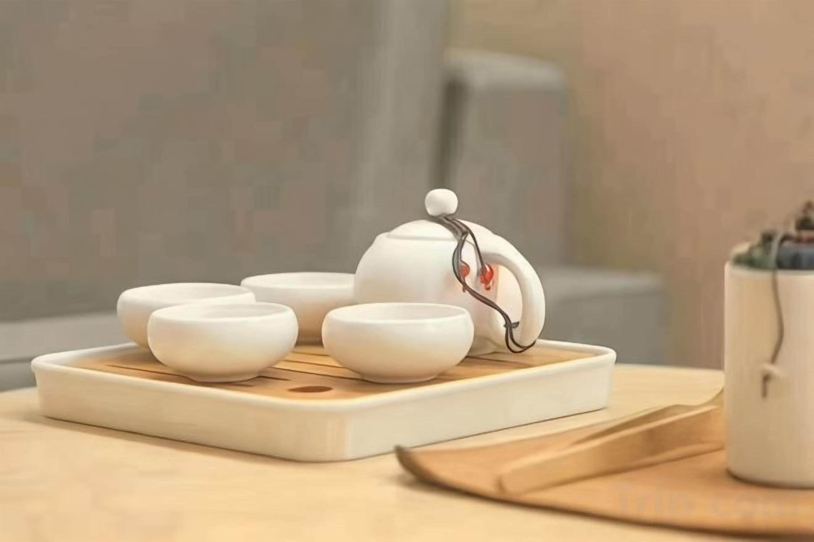 A white teapot with a lid and four white teacups on a tray.