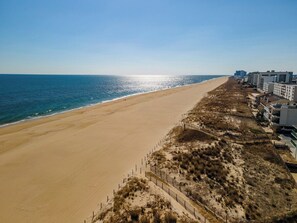 A beach with a sandy shore, a fence, and buildings in the background. - 1 Bedroom, Sleeps 4, Balcony w/ Ocean View (Ocean City)