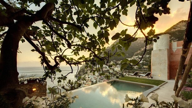 Une piscine avec vue sur la mer et un paysage montagneux.