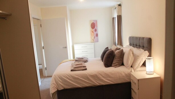 A bedroom with a bed, bedside table, and a wall-mounted artwork. - Remarkable 2-bed Apartment in Reading (Reading)