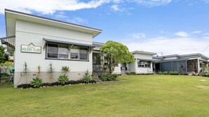 A modern two-story house with a well-maintained lawn and a sign indicating 'Holiday Flats'. - RYDER FLATS UNIT 2 - Close to Beaches (South West Rocks)