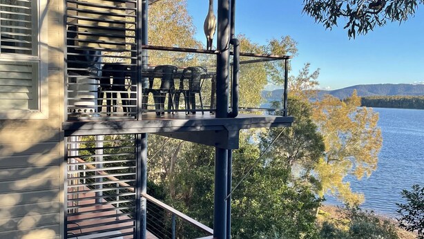 A two-story house with a balcony overlooking a lake. - Absolute lake front - lie in bed & listen to the fish jump! (Green Point)