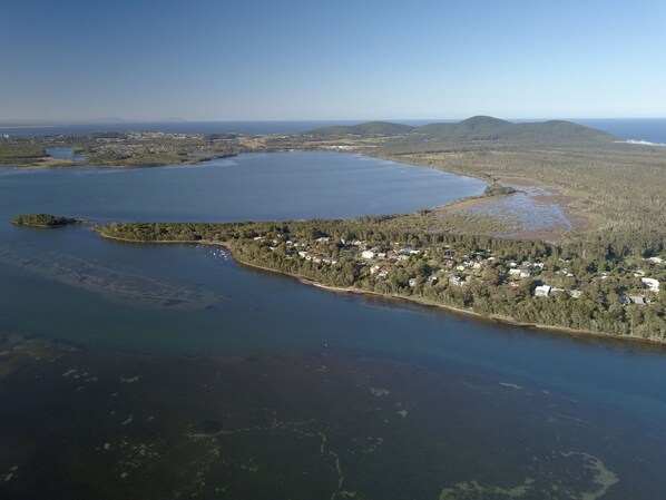 An aerial view of a coastal area with a small island, a large body of water, and a forested peninsula. - Absolute lake front - lie in bed & listen to the fish jump! (Green Point)