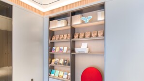 A modern interior with a bookshelf, a red chair, and a ceiling light.