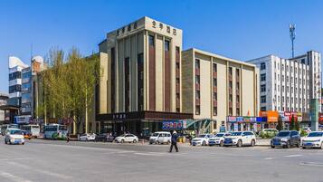 A hotel with a modern facade, multiple floors, and a prominent entrance.