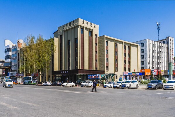 A hotel with a modern facade, multiple floors, and a prominent entrance.