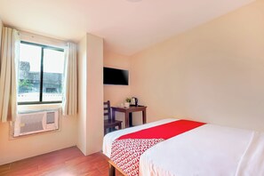 A hotel room with a bed, a desk, a chair, a TV, and a window with curtains. - Vaccinated Staff - OYO 847 Cote D' Azure (Las Pinas)