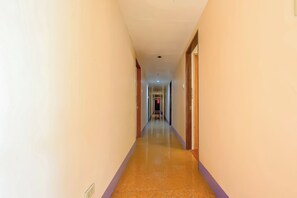 A hotel hallway with a tiled floor, doors on both sides, and a light fixture on the ceiling. - Vaccinated Staff - OYO 847 Cote D' Azure (Las Pinas)