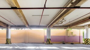 An empty parking garage with concrete floors, metal beams, and pillars. - Vaccinated Staff - OYO 847 Cote D' Azure (Las Pinas)
