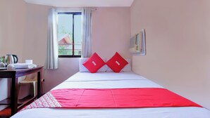 A hotel room with a bed, a desk, a chair, a window with curtains, and a wall-mounted air conditioner. - Vaccinated Staff - OYO 847 Cote D' Azure (Las Pinas)