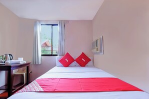 A hotel room with a bed, a desk, a chair, a window with curtains, and a wall-mounted air conditioner. - Vaccinated Staff - OYO 847 Cote D' Azure (Las Pinas)