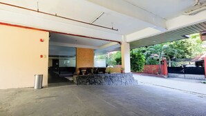 An indoor area with a reception desk, a stone wall, and a covered outdoor section. - Vaccinated Staff - OYO 847 Cote D' Azure (Las Pinas)