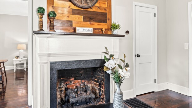 A fireplace with a "WELCOME" sign, a clock, and a vase with flowers. - Clayton's 1910, Completely Restored Mill House, business-friendly weekday rates (Graham)