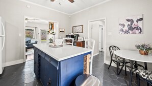 A modern kitchen with a central island, white cabinetry, and a ceiling fan. - Clayton's 1910, Completely Restored Mill House, business-friendly weekday rates (Graham)