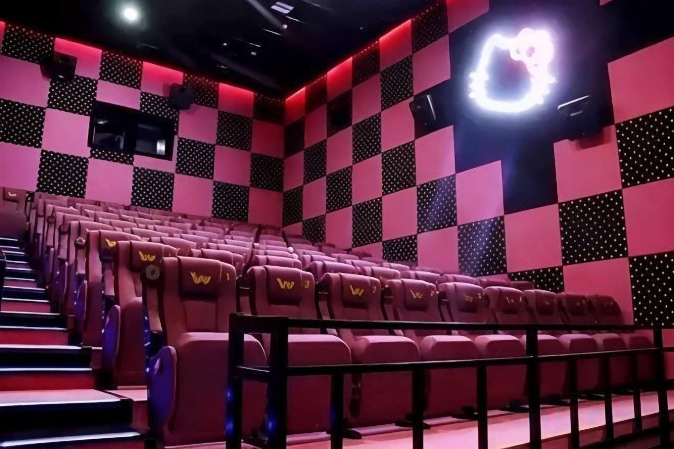Ein Auditorium mit Reihen von Sitzplätzen, einer Bühne und einem Schachbrettmuster an der Wand.