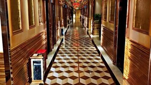 A hotel corridor with a checkered floor, wooden paneling, and a red bench. - Qinyuan Zhixuan Hot Spring Hotel (Sanyuan)