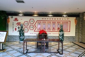 A conference room with a large banner, a table, and chairs. - Qinyuan Zhixuan Hot Spring Hotel (Sanyuan)