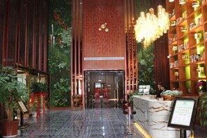 A hotel lobby with a reception desk, a large chandelier, and a wall of bookshelves. - Qinyuan Zhixuan Hot Spring Hotel (Sanyuan)