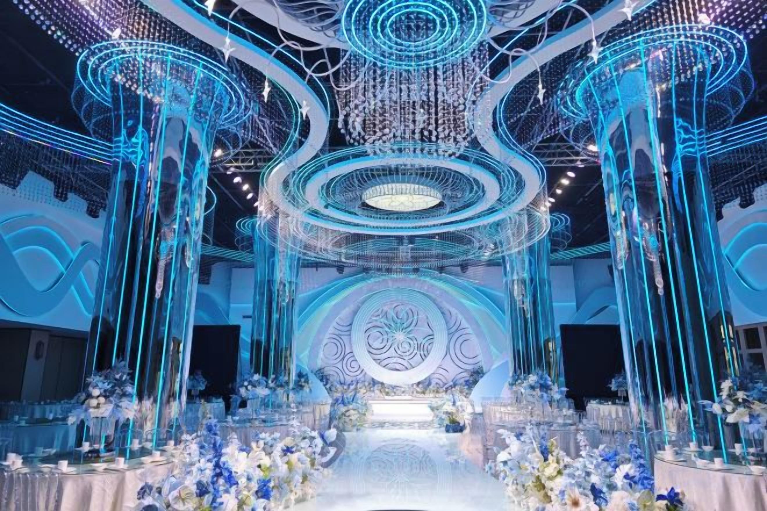 A venue with a central stage, multiple seating areas, and decorative lighting fixtures.