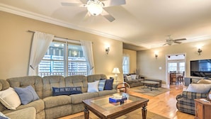 A spacious living room with a sectional sofa, a coffee table, and a television. - Beautiful Spacious Beach Home, Private Deck & Grill, 5-min to Beach w/ Badges (Point Pleasant Beach)