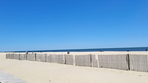A beach with a wooden boardwalk and a fence. - Beautiful Spacious Beach Home, Private Deck & Grill, 5-min to Beach w/ Badges (Point Pleasant Beach)